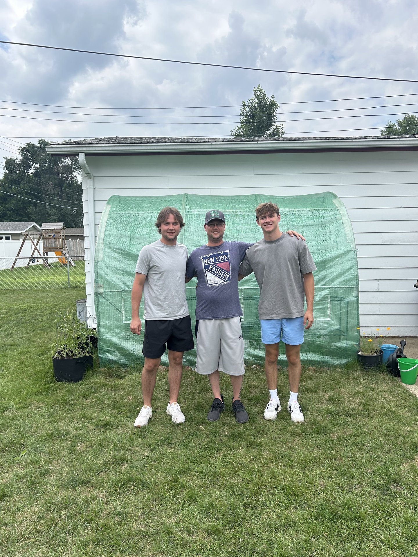 Derwin Hauser with his dad and brother in the backyard