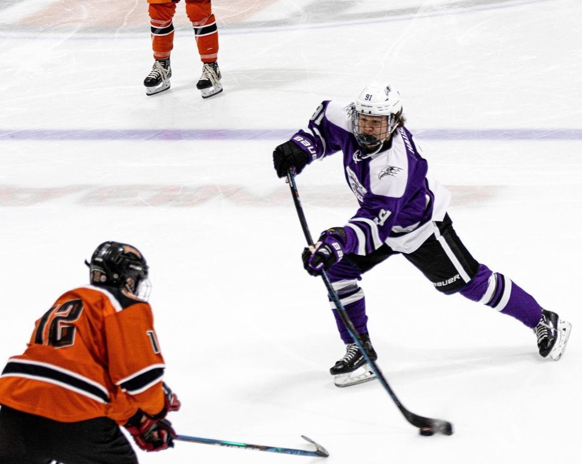Derwin Hauser shooting a puck through a defender