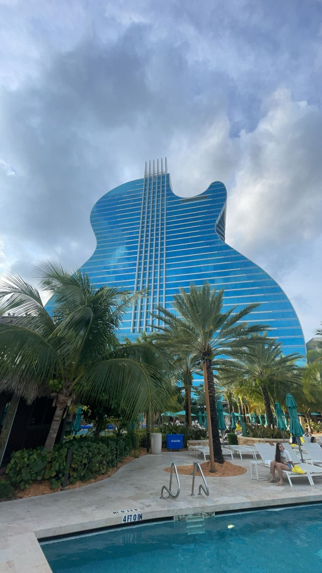 hard rock guitar-shaped hotel, towering behind palm trees